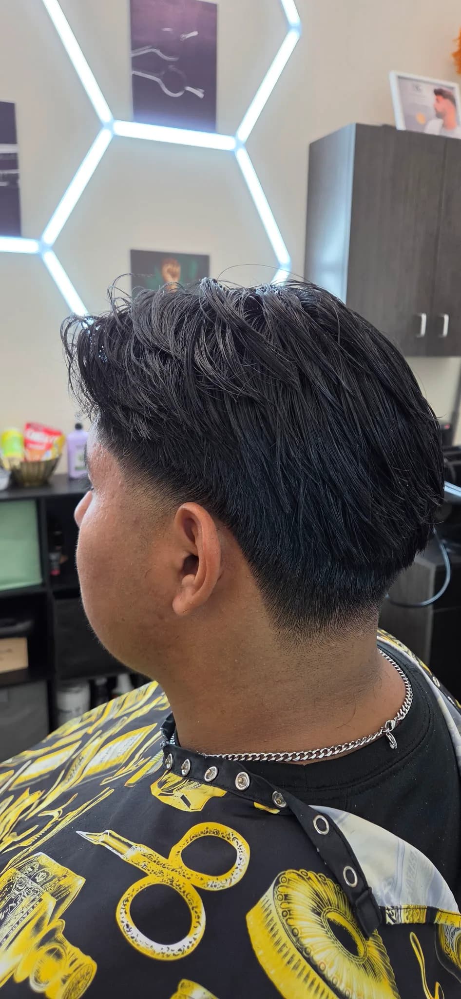 Slicked-back haircut with a clean low taper